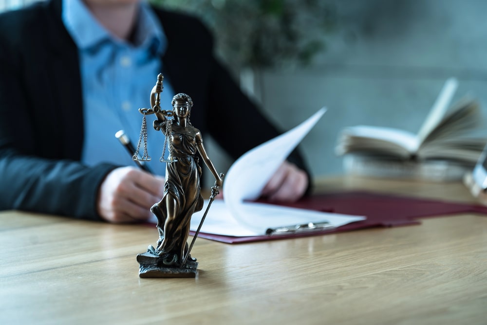 Lady Justice statue on lawyer’s desk with legal documents, representing personal injury law in Kenilworth NJ