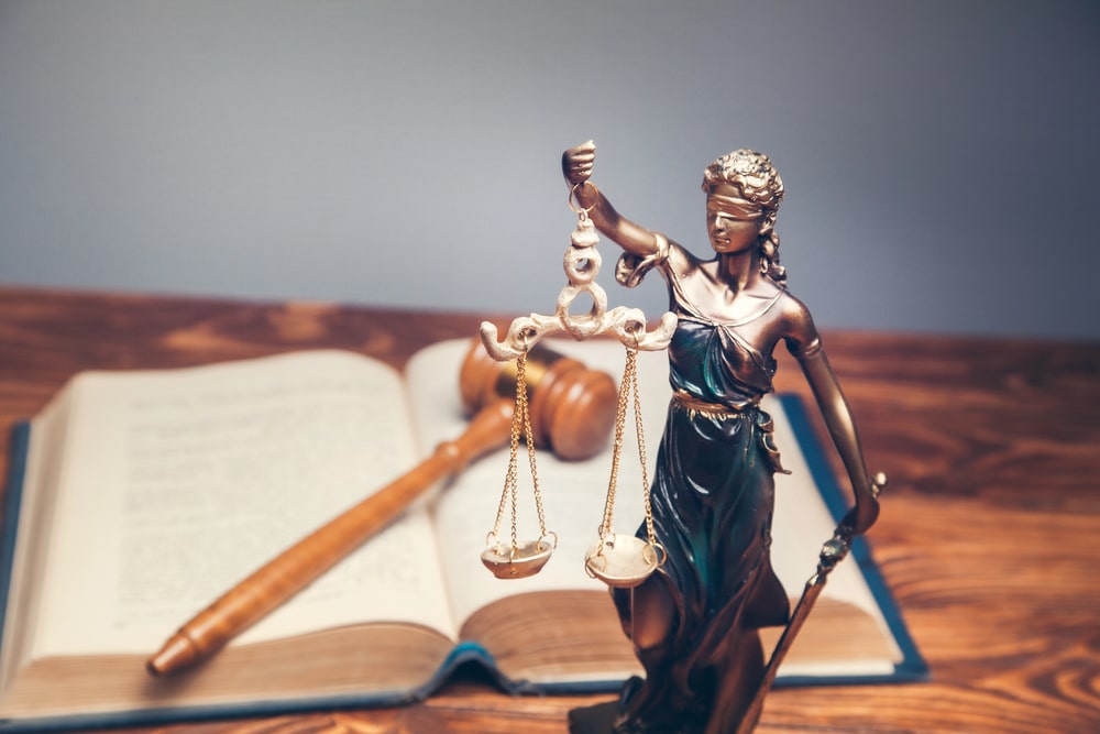 Lady Justice statue with gavel and open law book in background, representing personal injury law in East Orange NJ.