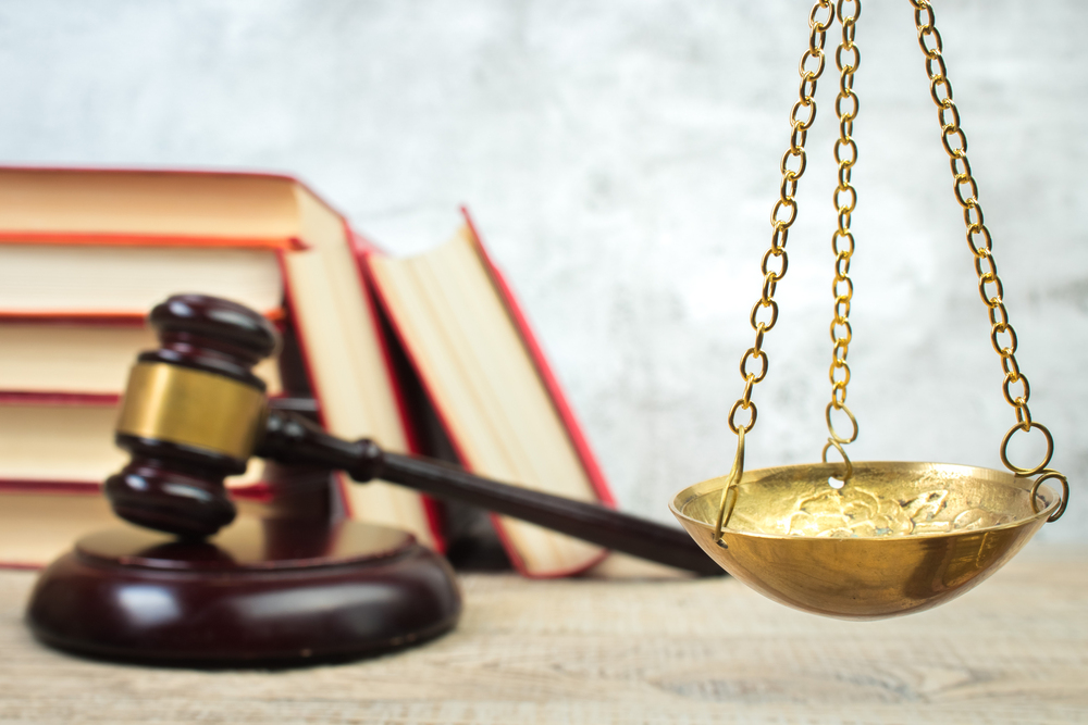 Judge’s gavel, legal books, and brass balance scale symbolizing justice and legal representation in Piscataway, NJ.