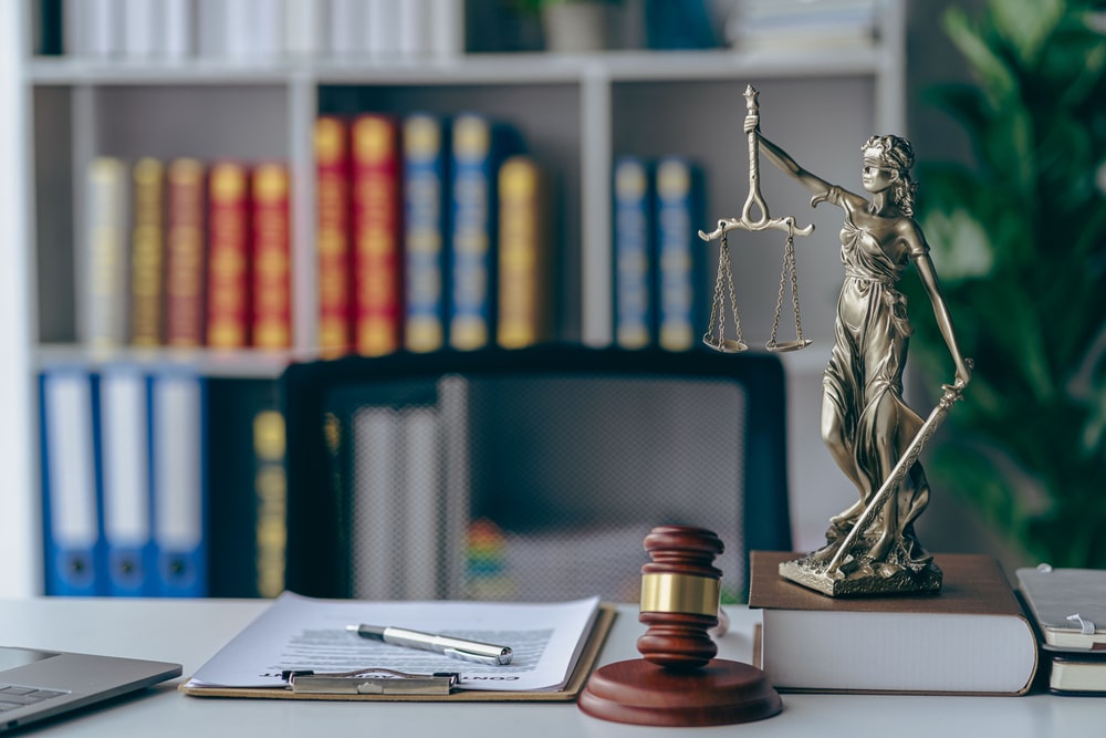 Lady Justice statue, gavel, and legal documents on a lawyer’s desk representing personal injury legal services in New Jersey