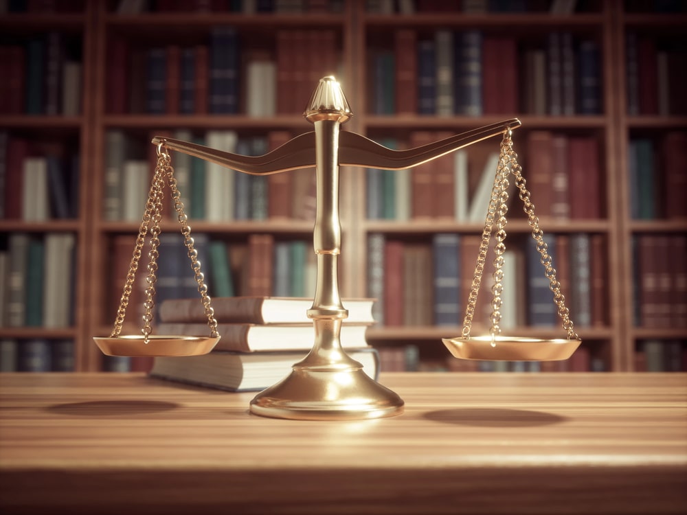 Golden scales of justice and law books in library setting, representing personal injury law in Sayreville NJ.